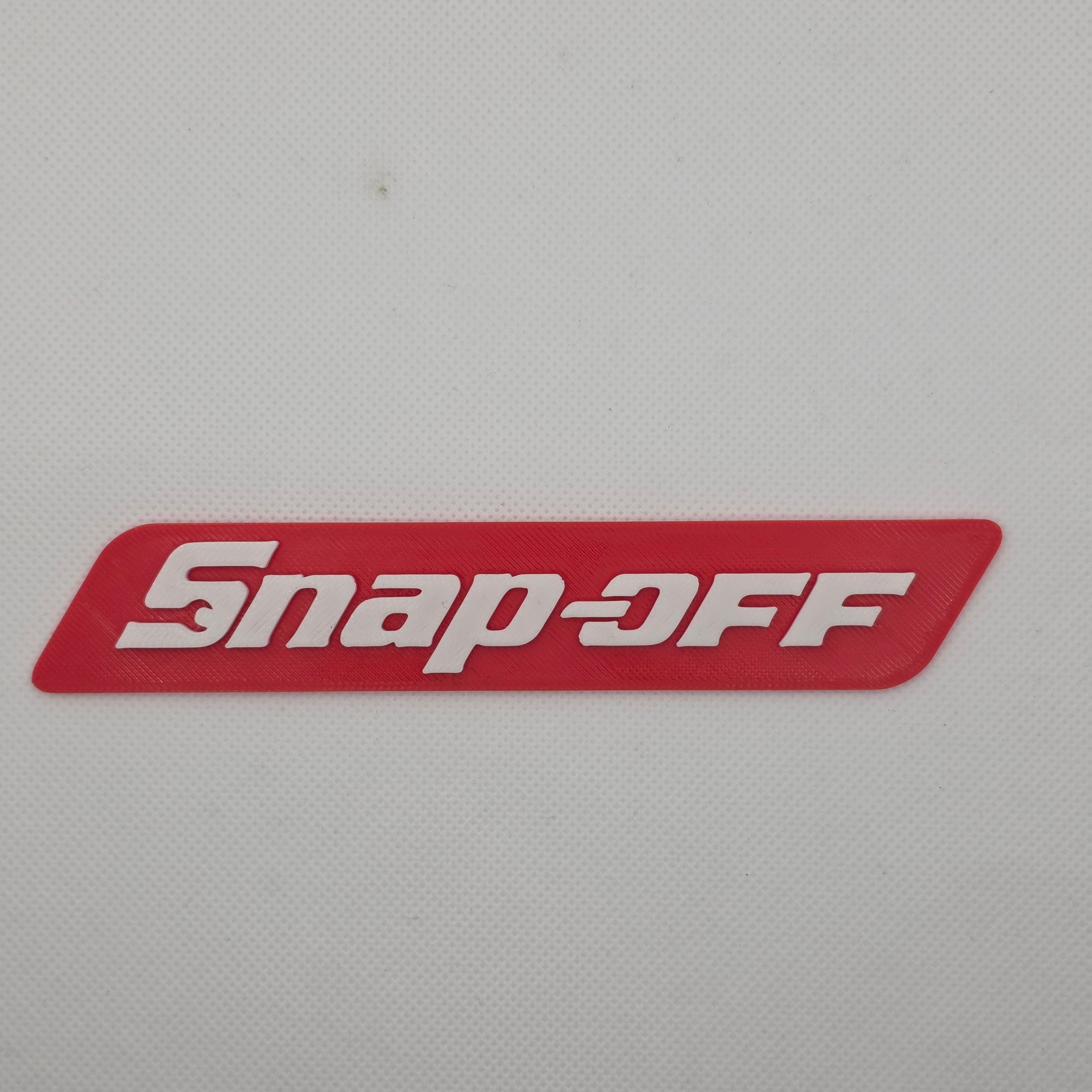Snap-off novelty toolbox badge
